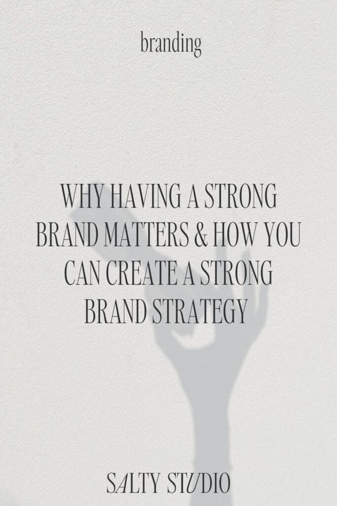 Text reads "How to Create a Website Backed by Strategy." Below, a shadow of a hand holding a phone creates a minimalist, artistic vibe. Button says "Learn More."