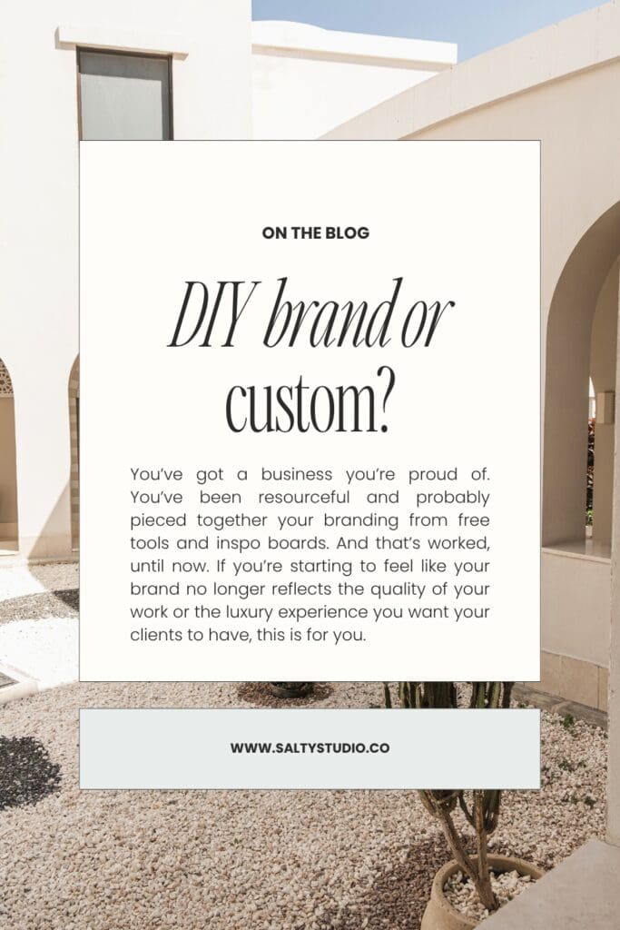 Alt text: "White minimalist blog graphic titled 'DIY brand or custom?' overlaid on an architectural photo of arched, sunlit building. URL: www.saltystudio.co."